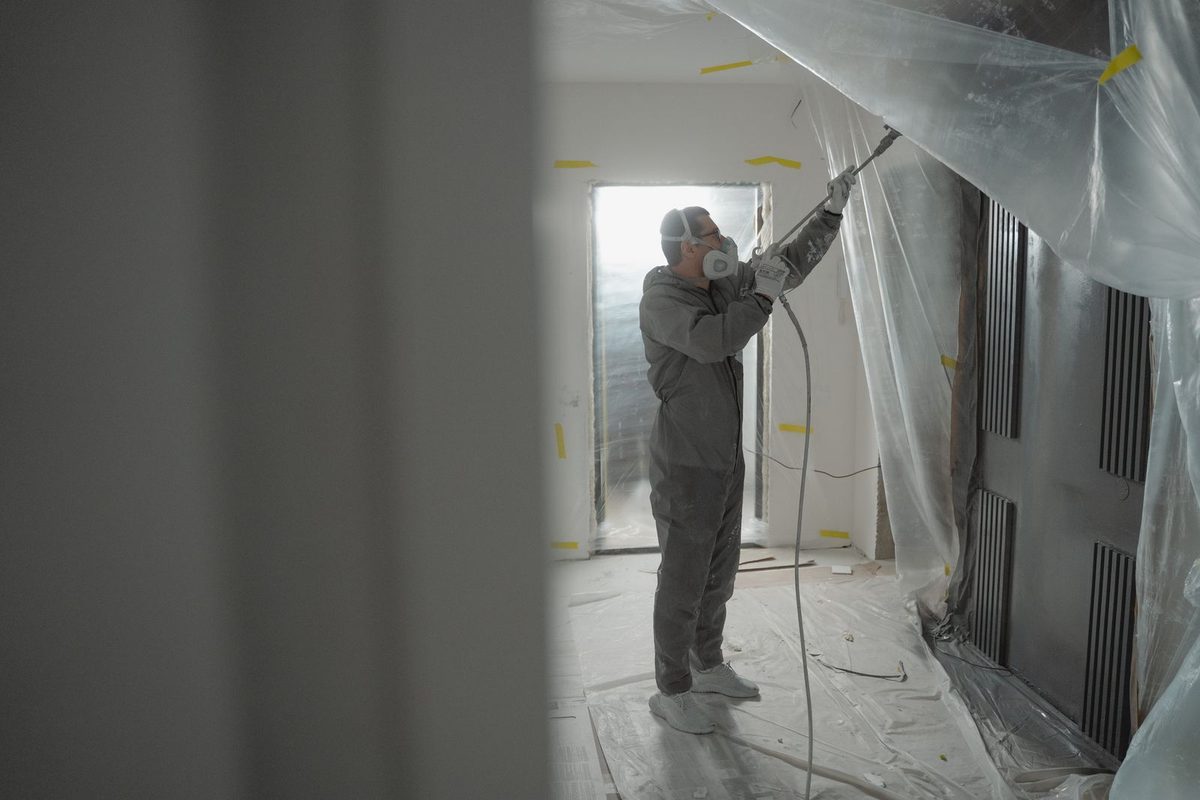 Painter spraying an interior wall
